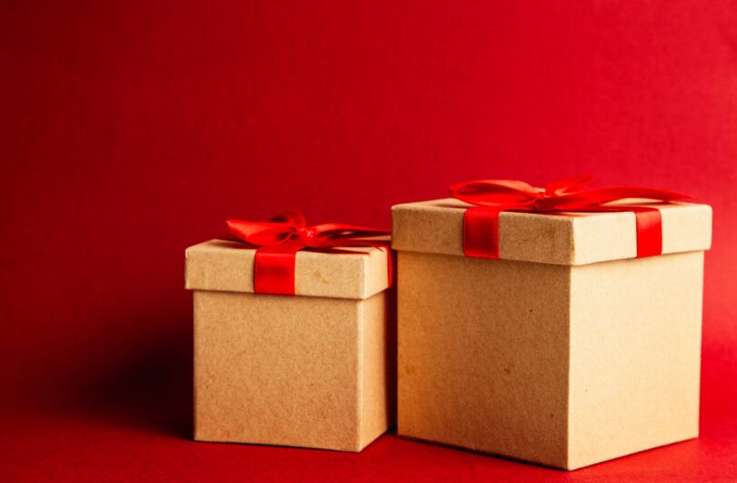 two brown and red gift boxes on red surface