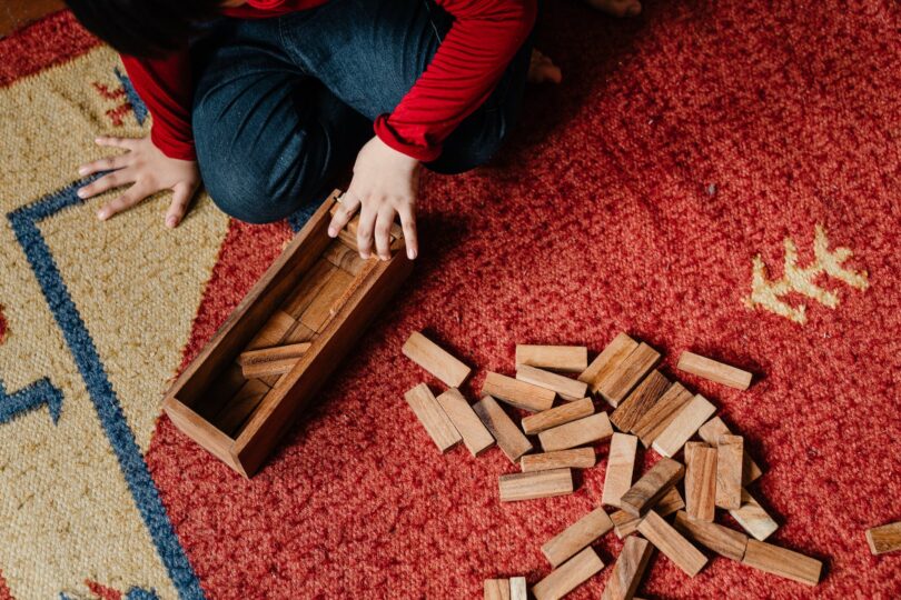 unrecognizable child playing jenga at home
