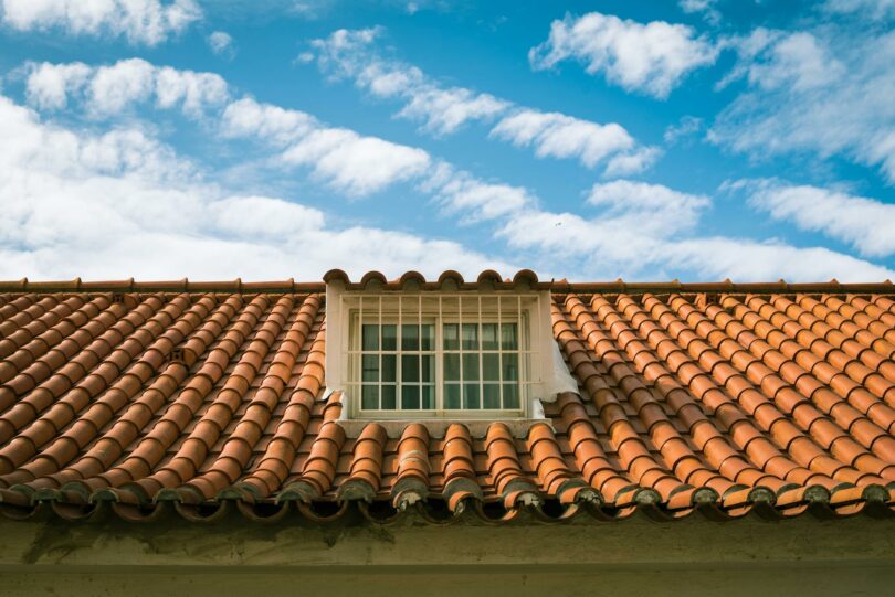 a roof with a window and a blue sky
