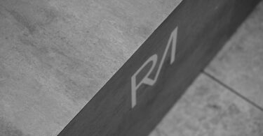 grayscale photo of initials on concrete surface