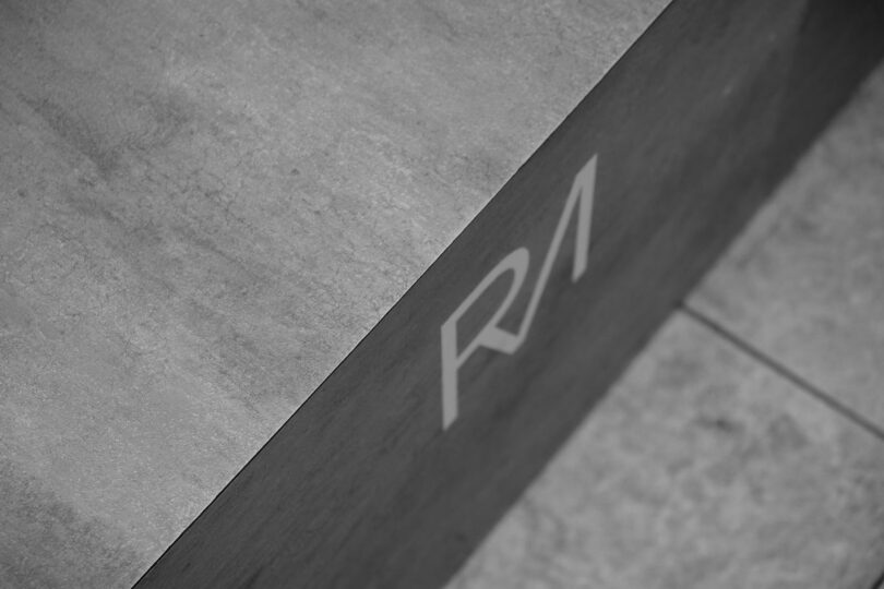 grayscale photo of initials on concrete surface