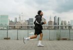 man wearing jacket and black shorts running in the city